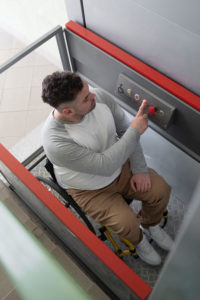 chico en silla de ruedan subiendo en un ascensor
